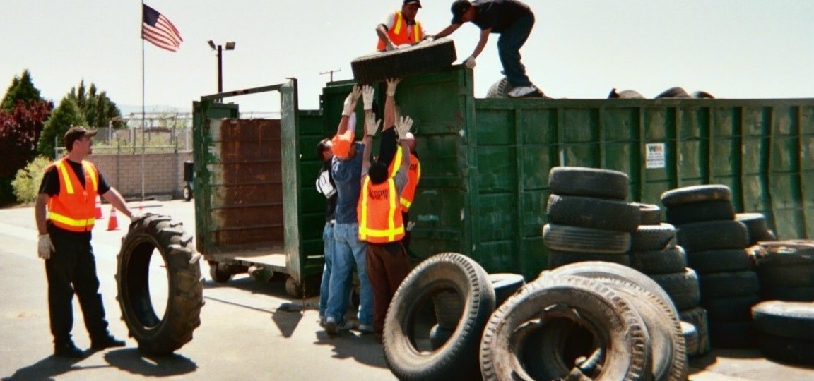 workers load tires into bins